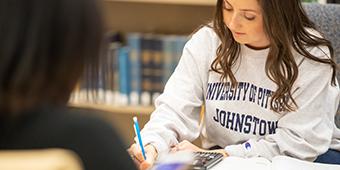student studying in library at Pitt-Johnstown campus