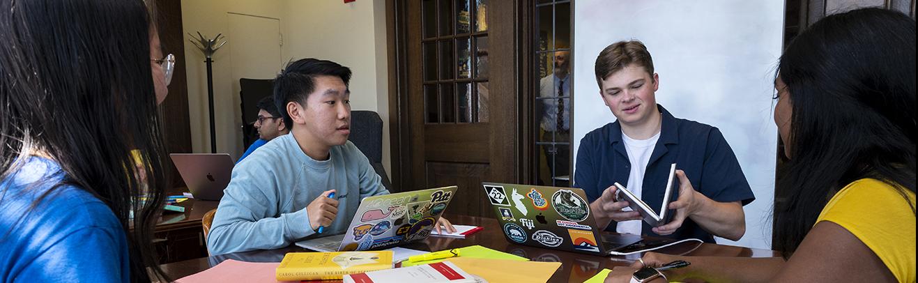 four Honors College students gather around a round table to study together.